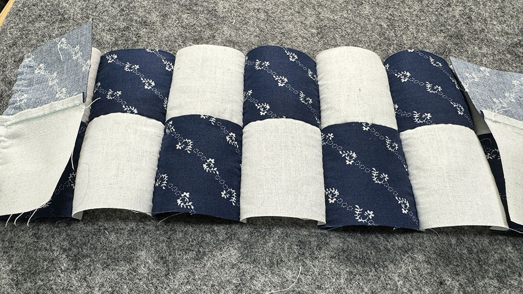 Nine 2-patch pieced together, viewed from the front. The vertical seams haven't been pressed and it makes the entire block look very wobbly.