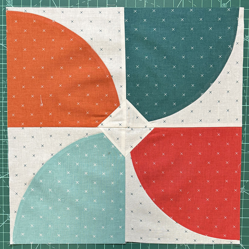 4 squares with a curved piece, meeting in the center, giving the impression of an old plane propeller