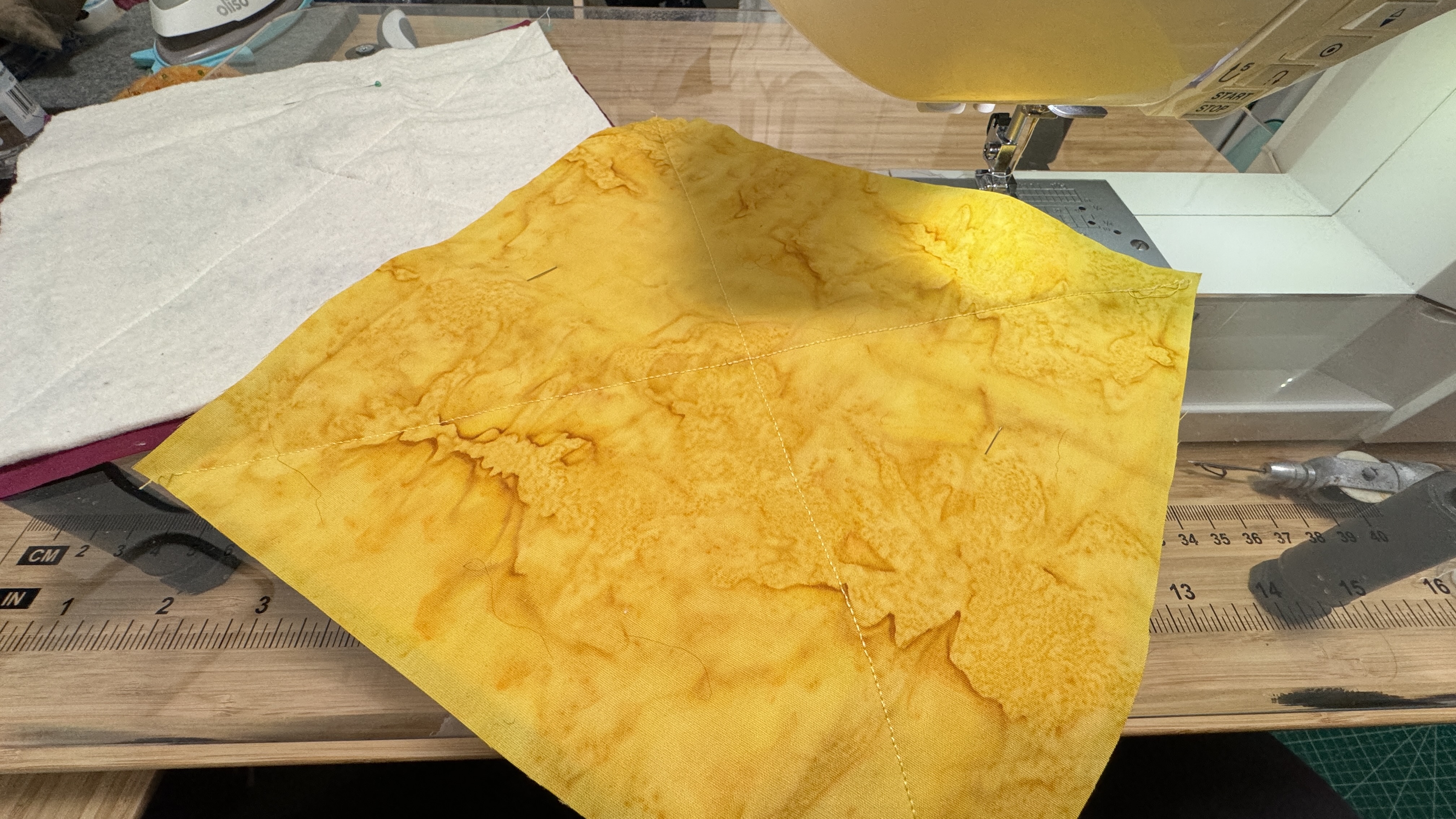 Yellow batik with an X shaped seam from corner to corner.