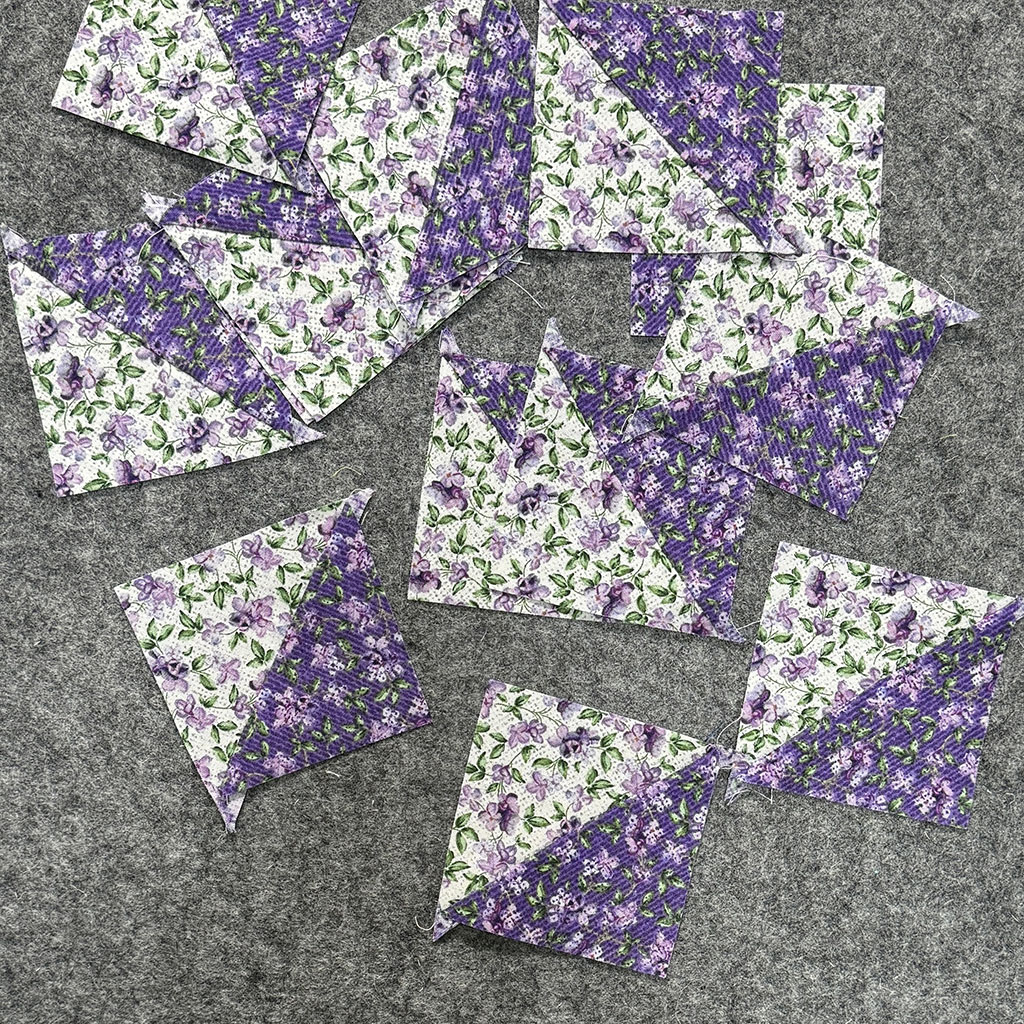 Several light and dark triangles sewn into squares, long sides together.