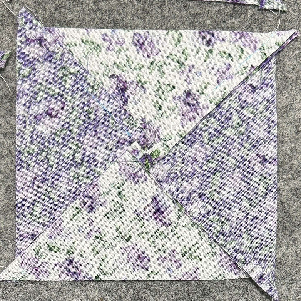 Back view of a square made of 4 triangles. The center seam is neatly fanned.