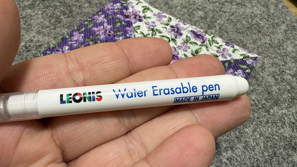 Mini Leonis water erasable marker held in an open hand.
