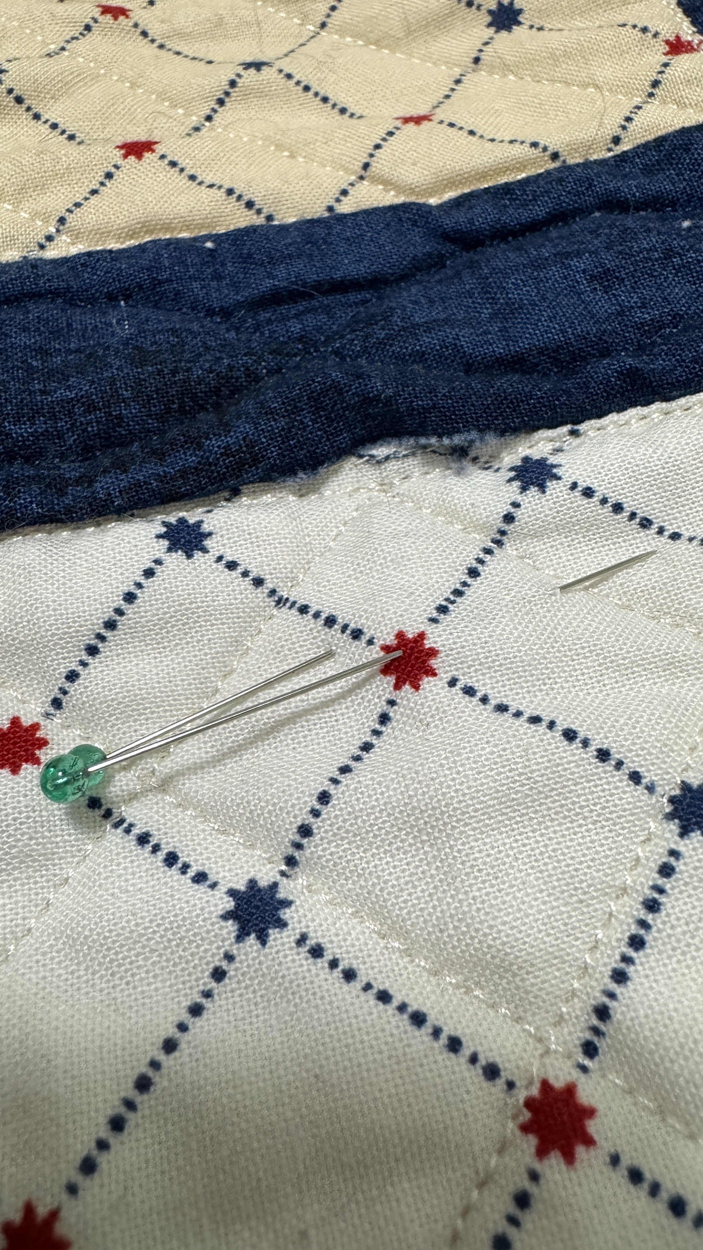 Close up of a seam on a quilt. It has come unstitched and the fabric is fraying.