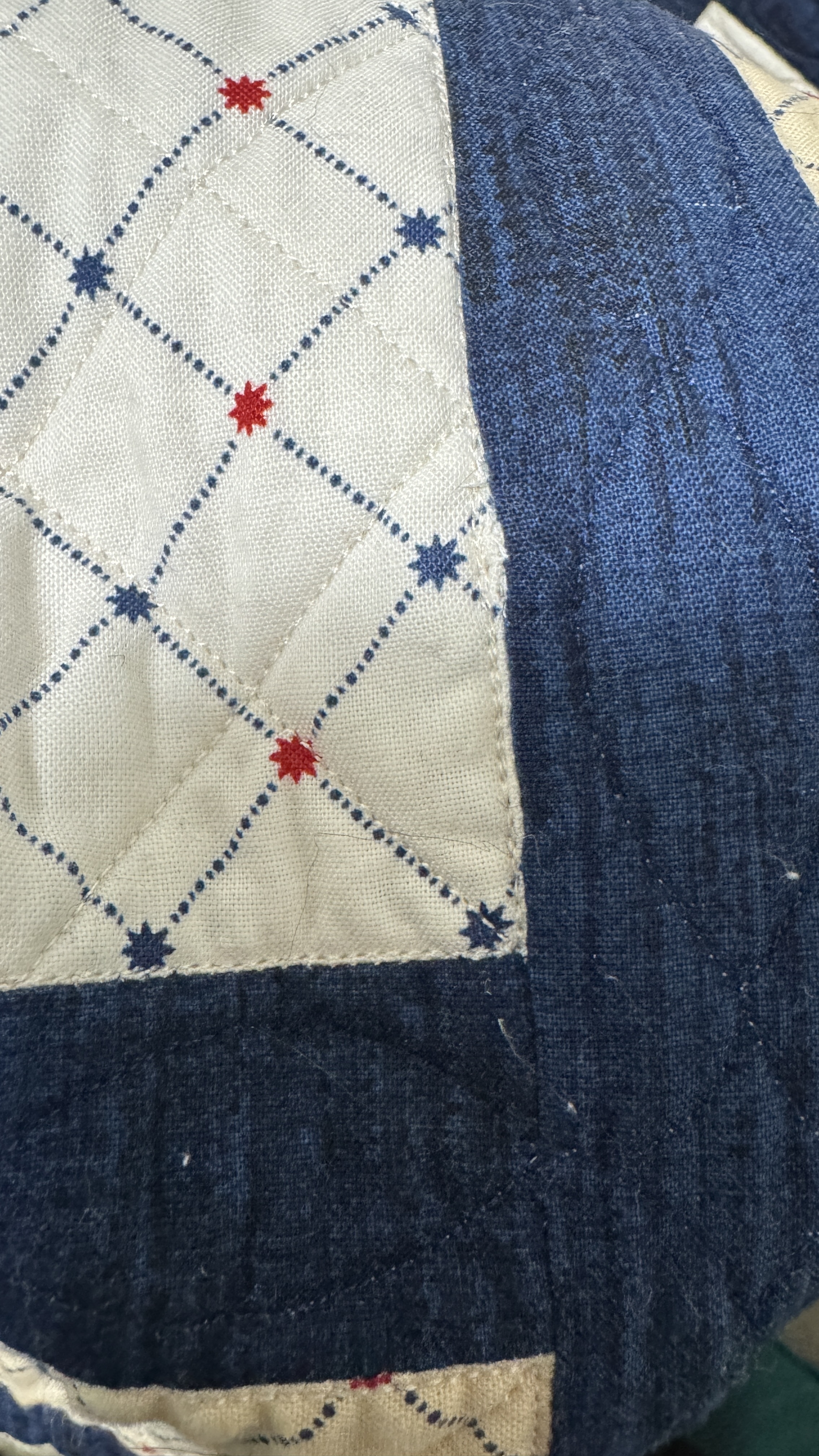 Close up of a seam on a quilt. It's hard to tell it was repaired.